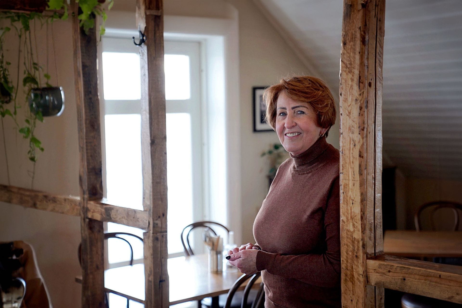 Kona horfir í myndavélina og stendur inn á veitingastað