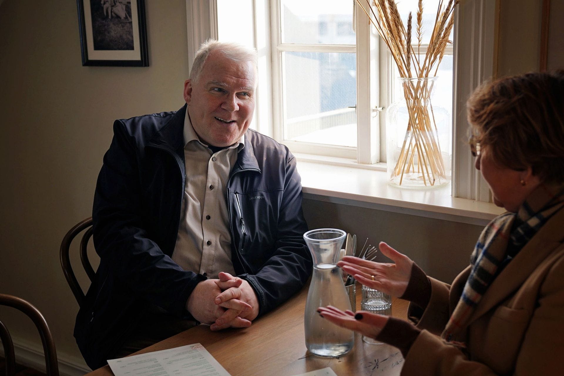 karlmaður situr við glugga