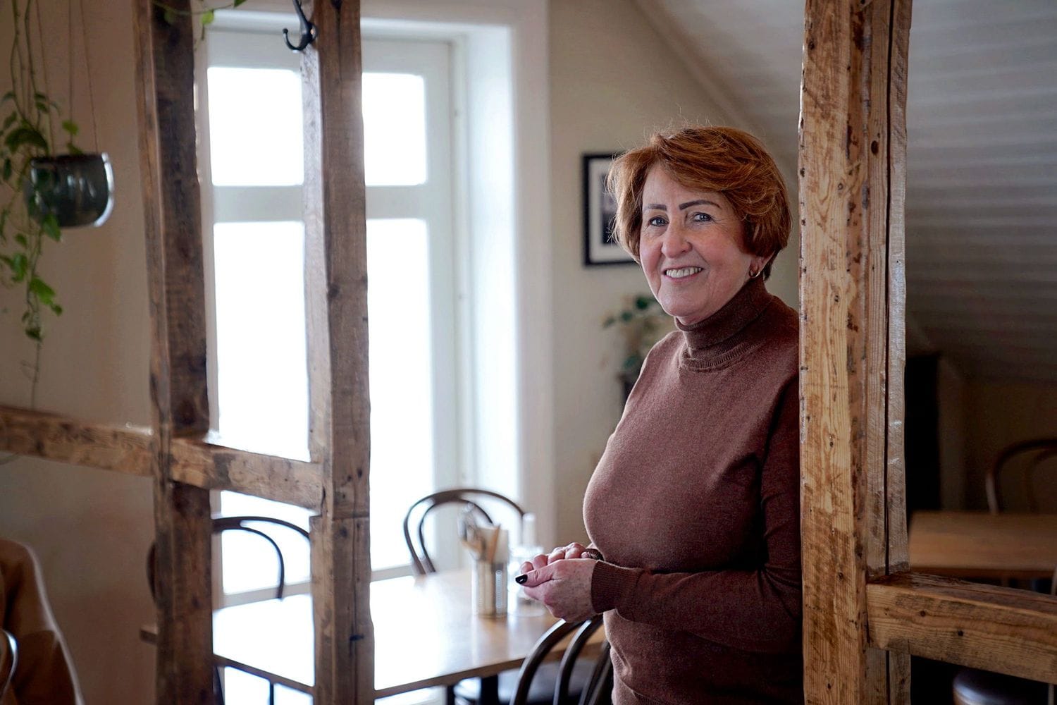 Kona sem stendur og brosir