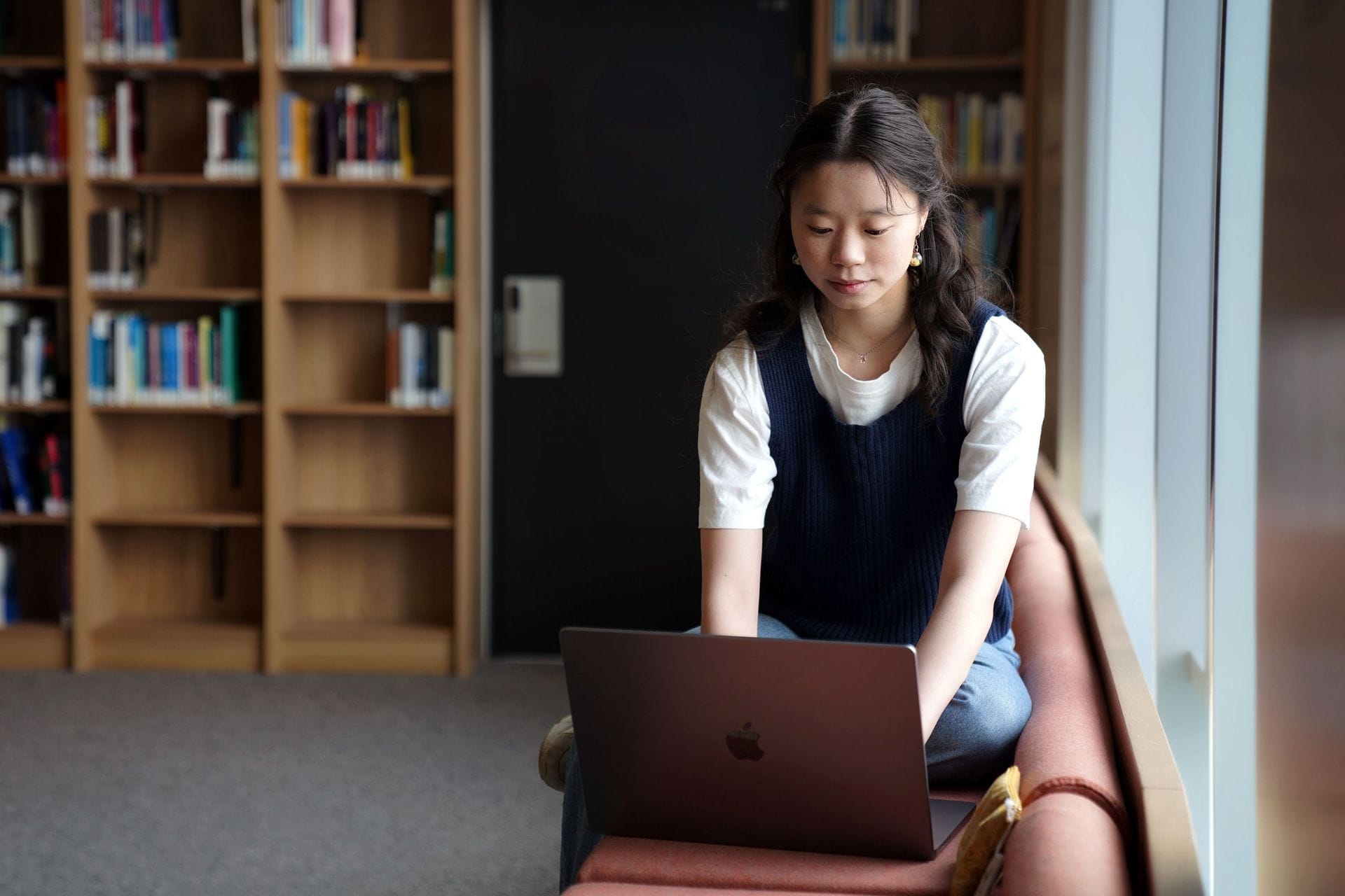 Ung kona situr og horfir á tölvu