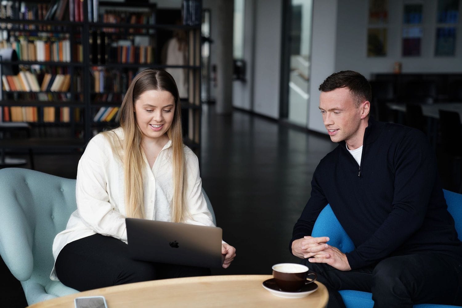 Ungt fólk sitjandi í sófum að skoða skjá tölvu