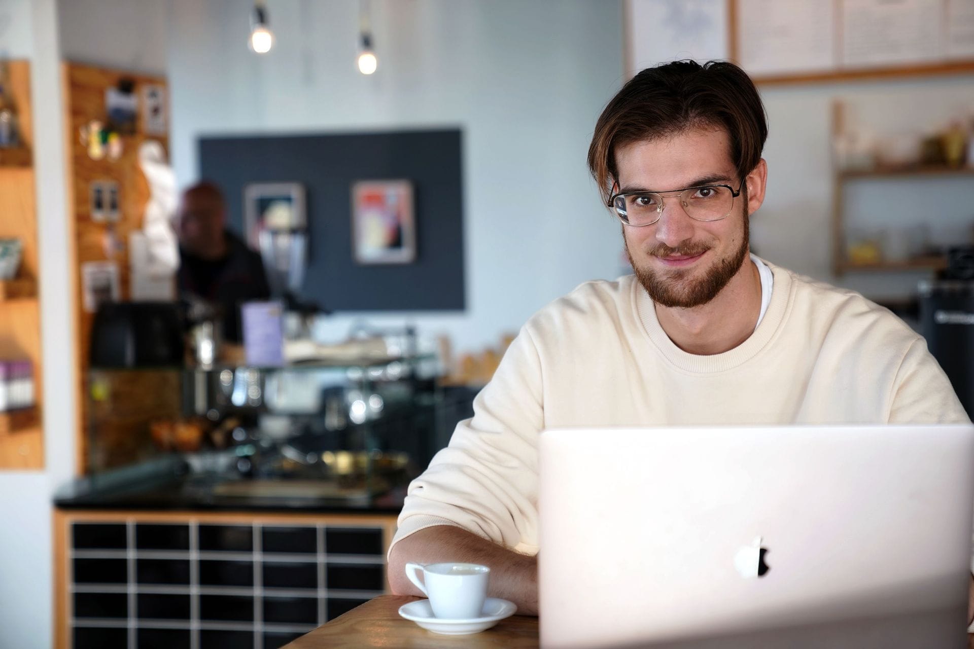 Ungur maður á kaffihúsi með tölvu