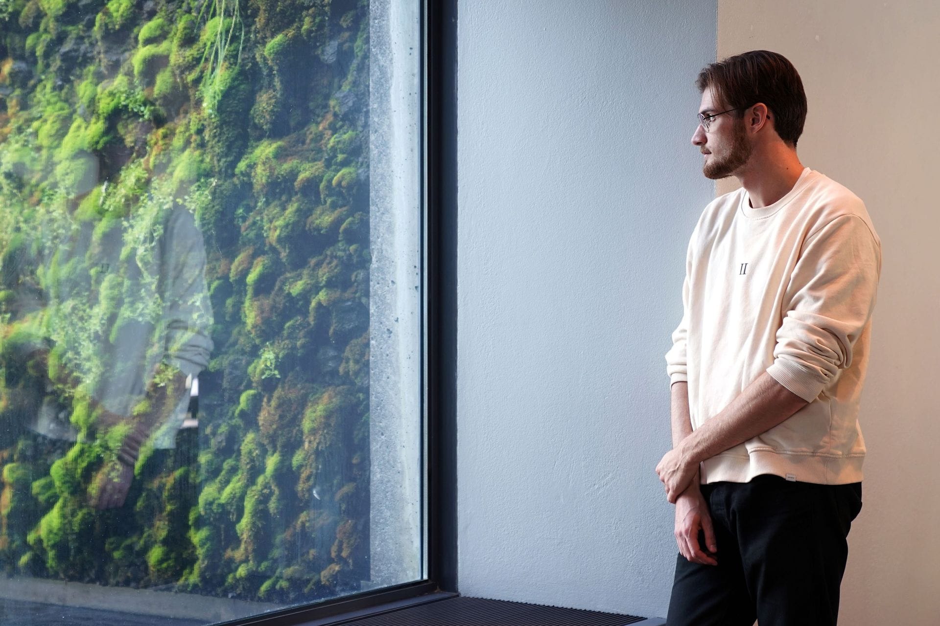 Ungur maður horfir út um glugga