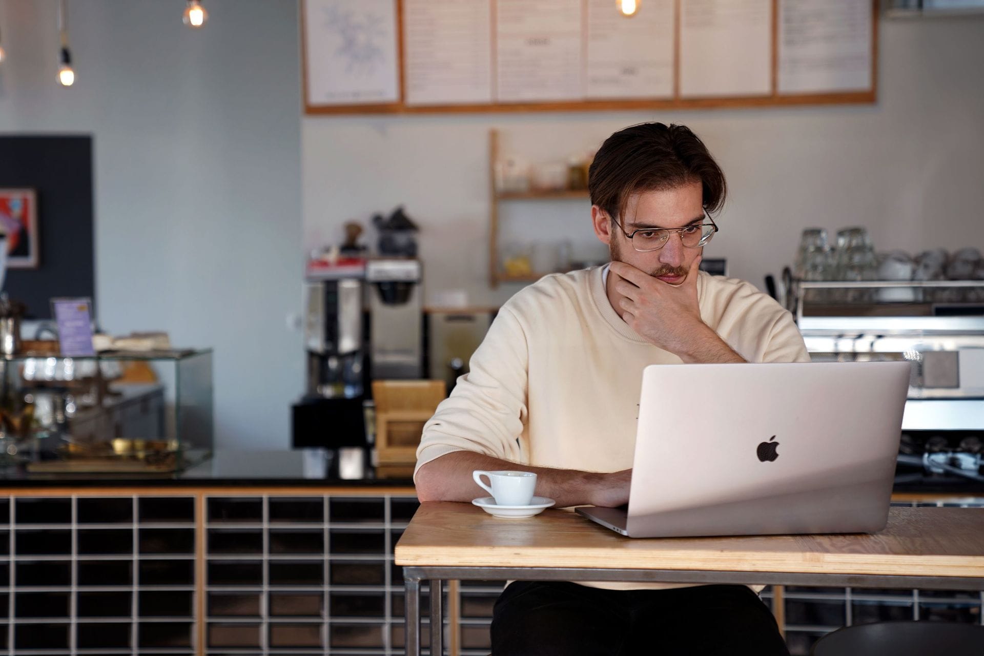ungur maður í tölvu á kaffihúsi horfir ekki í myndavél
