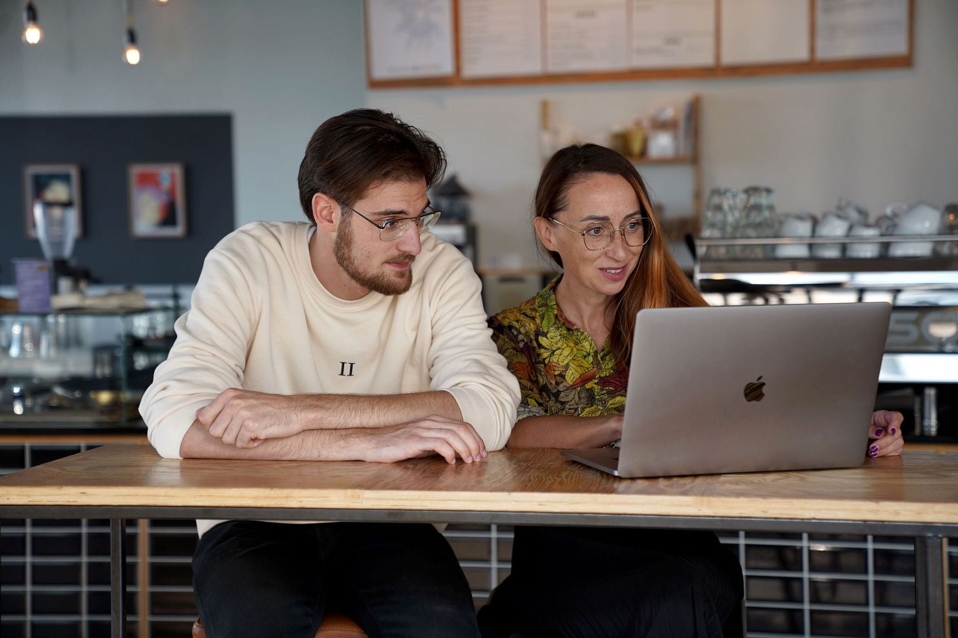 Ungur maður og ung kona í tölvu á kaffihúsi